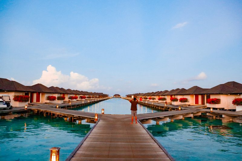 Overwater bungalows along a boardwalk at dusk in Fiji