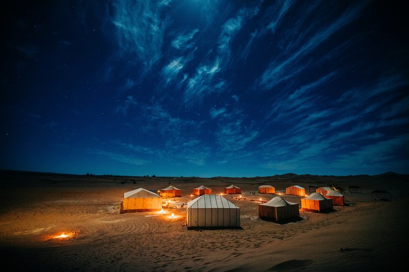 Luxury desert camp glowing under starry Sahara sky at night