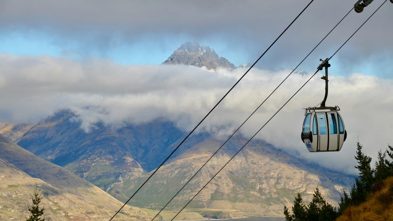 Skyline gondola ascending above Queenstown with Remarkables mountains