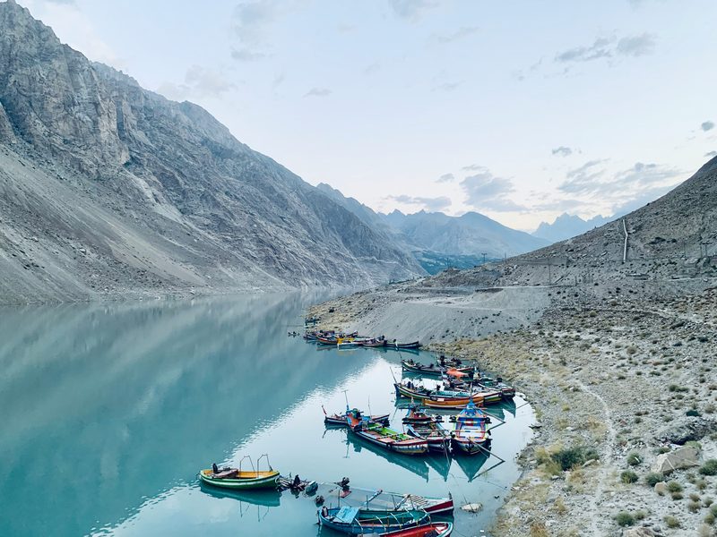 Colorful boats on turquoise Attabad Lake surrounded by Karakoram mountains