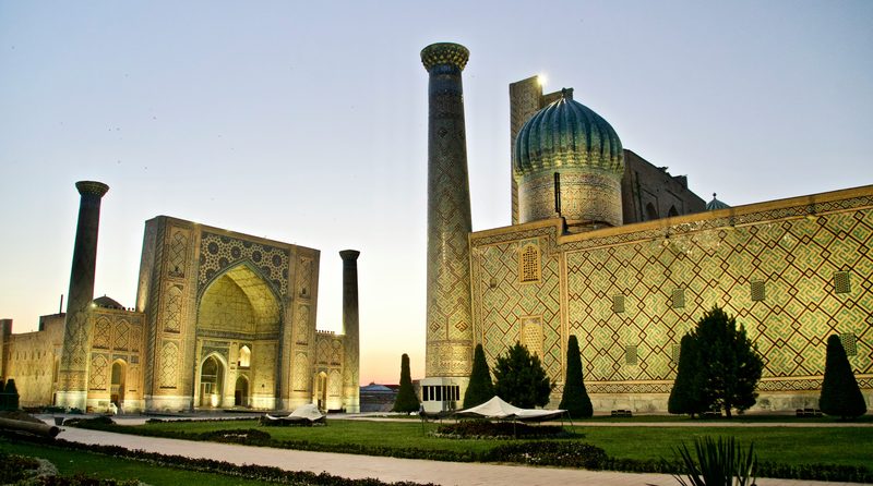 Samarkand Registan square at dusk with illuminated turquoise domes