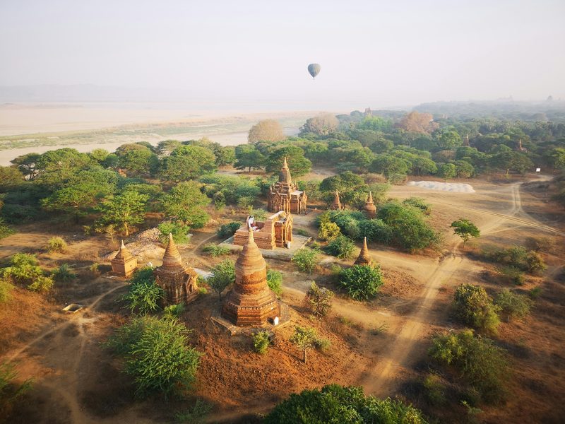Aerial view of ancient Bagan temples at sunrise with hot air balloon