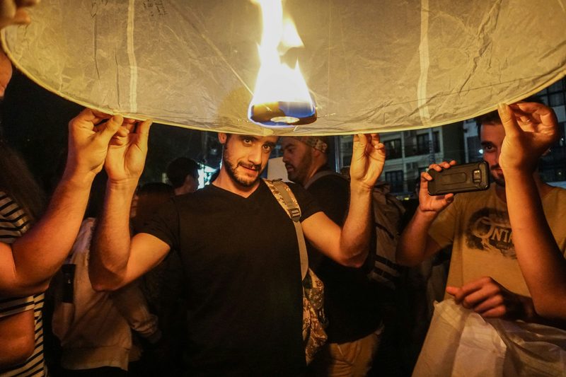 Travelers releasing a glowing Yi Peng sky lantern at Loi Krathong festival