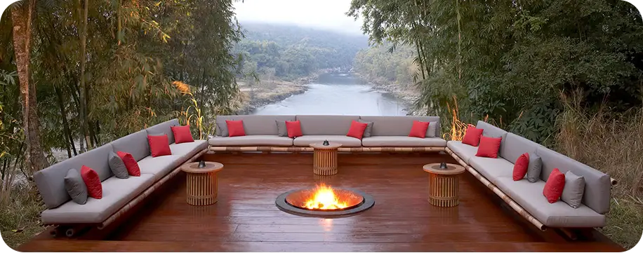 Large, comfortable, uncovered patio with a fire pit in the middle. The background shows the view of a river fading off into the horizon.