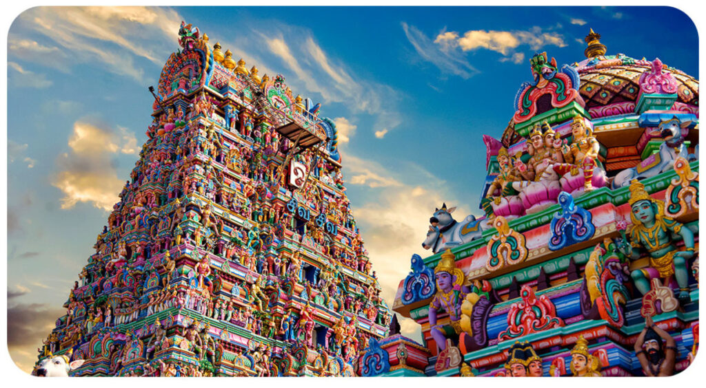 Elaborate and colorful statues and decorations on a temples. The sky looks blue in the bacground.