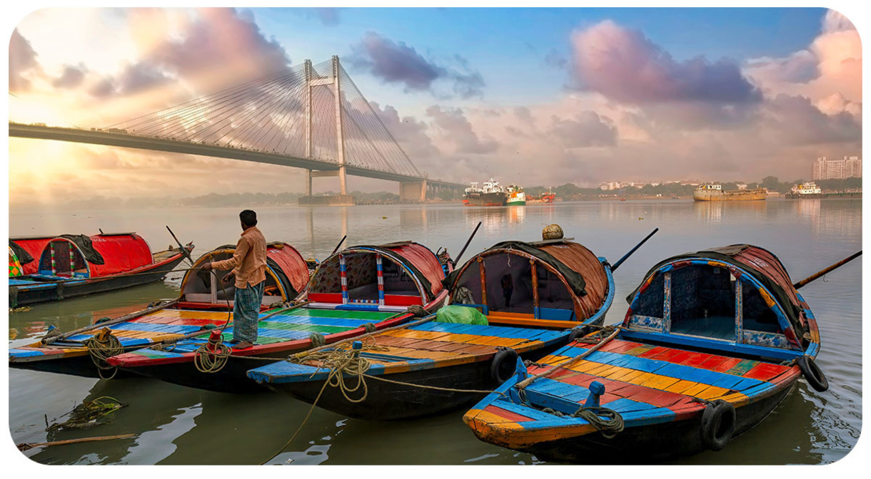 Colorful boats in the foreground. Hanging bridge over river in the background.