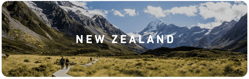 Hikers walking through a wide mountain valley in New Zealand